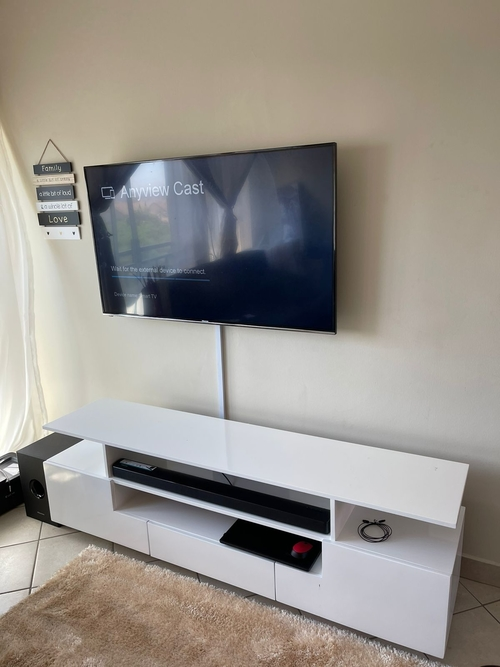 Handyman: Television mounted to the wall with a tv stand below it