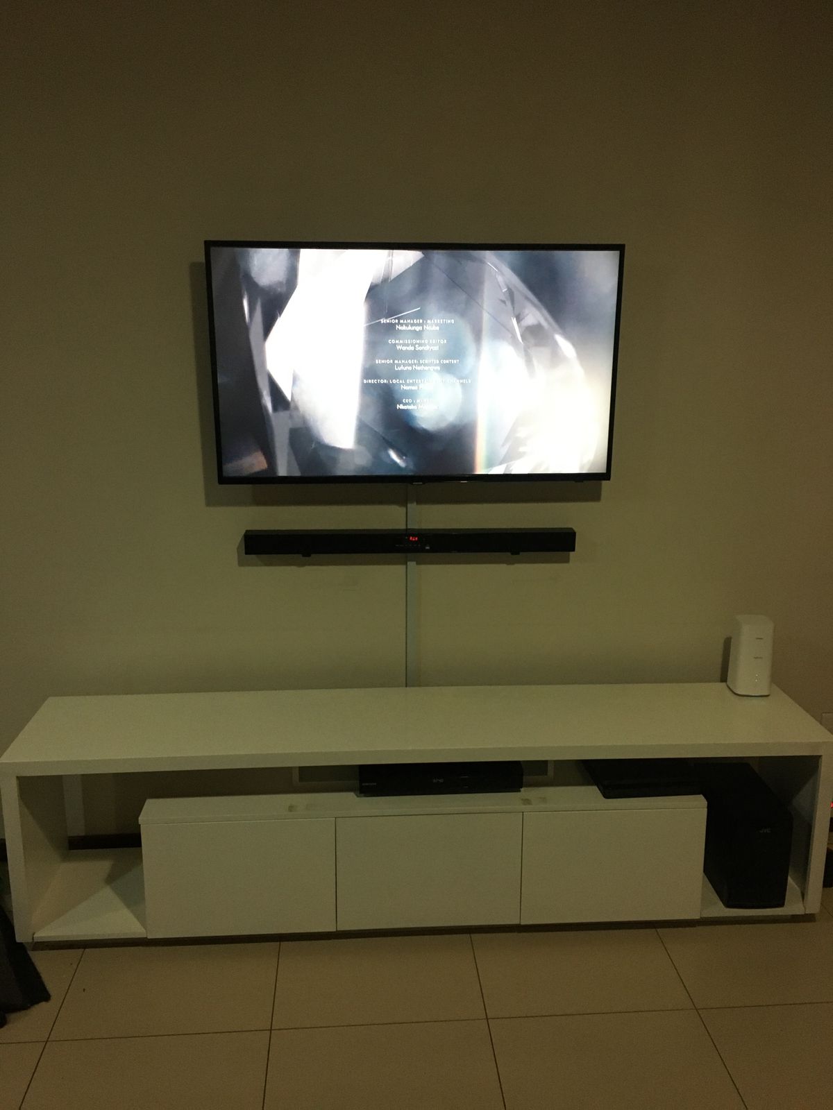 Handyman: Television mounted on the wall with sound bar underneath also mounted on the wall, all with tv stand underneath it.